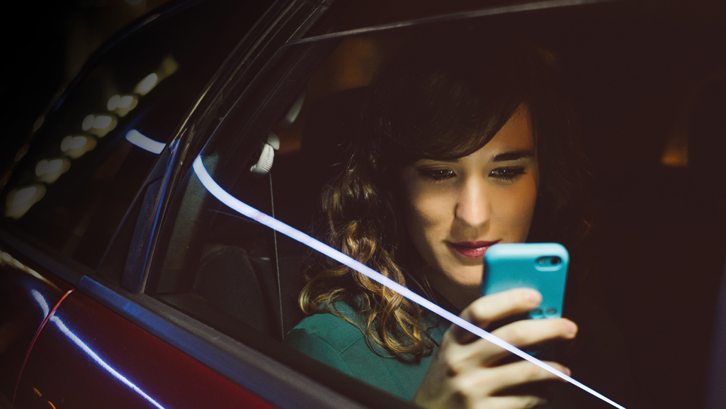 Frau mit Smartphone im Auto