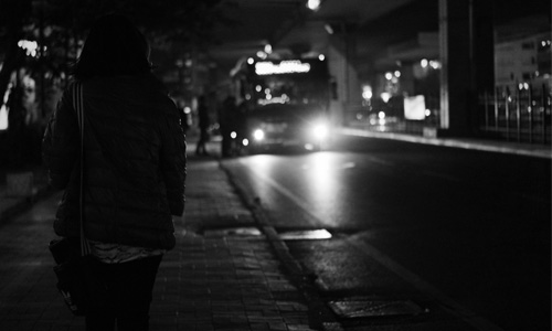 femme qui attend le bus al nuit