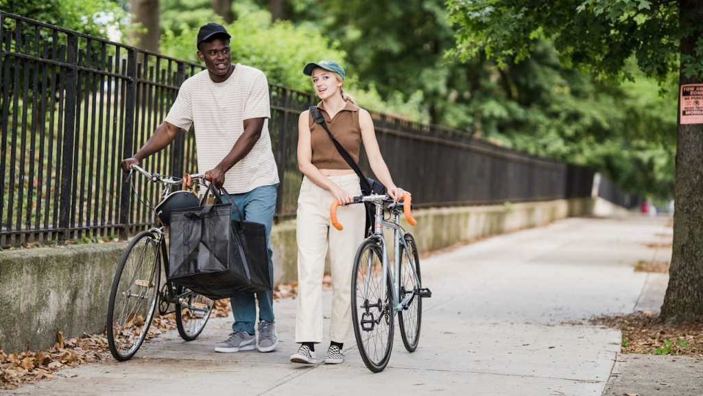 2 people walking with bikes